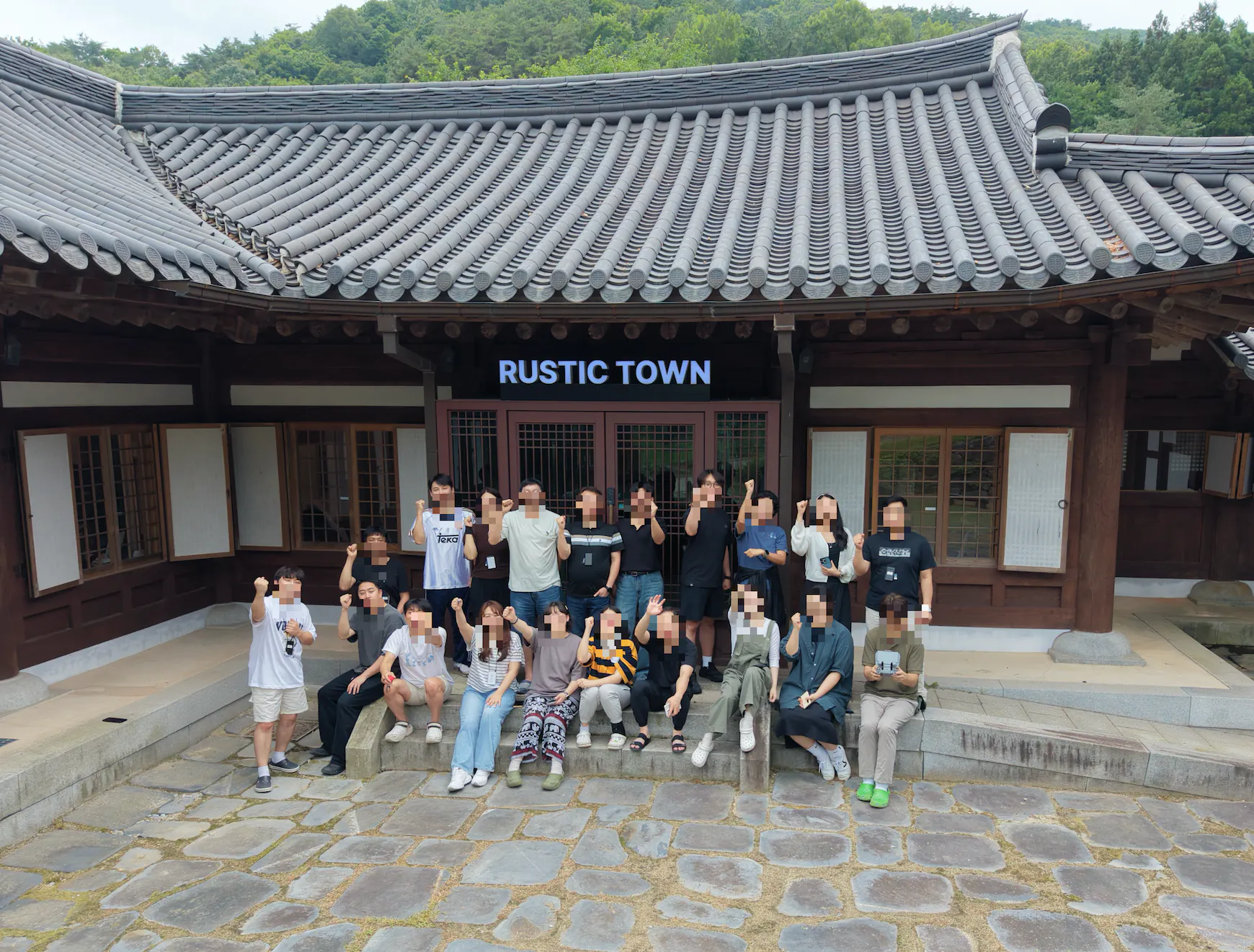 한 무리의 사람들이 건물 앞에서 포즈를 취하고 있다