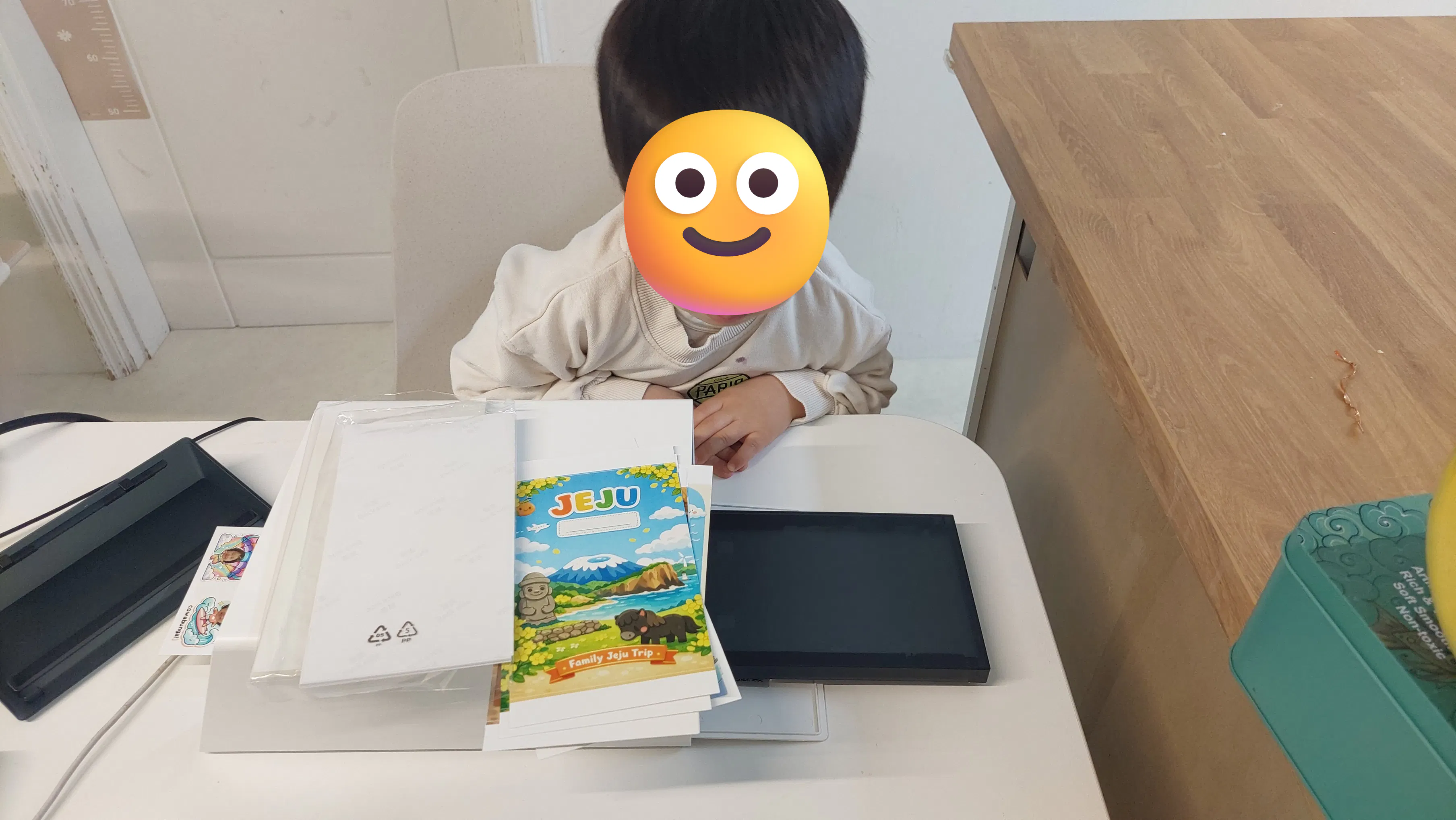 웃는 얼굴로 책상에 앉아 있는 소년