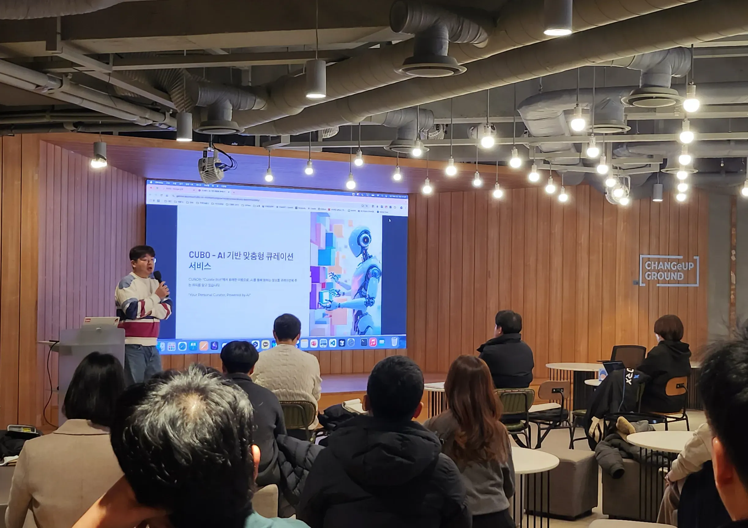 한 무리의 사람들이 스크린 앞 테이블에 앉아 있다