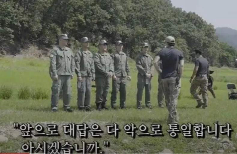 군복을 입은 한 무리의 남자들이 들판에 서 있다