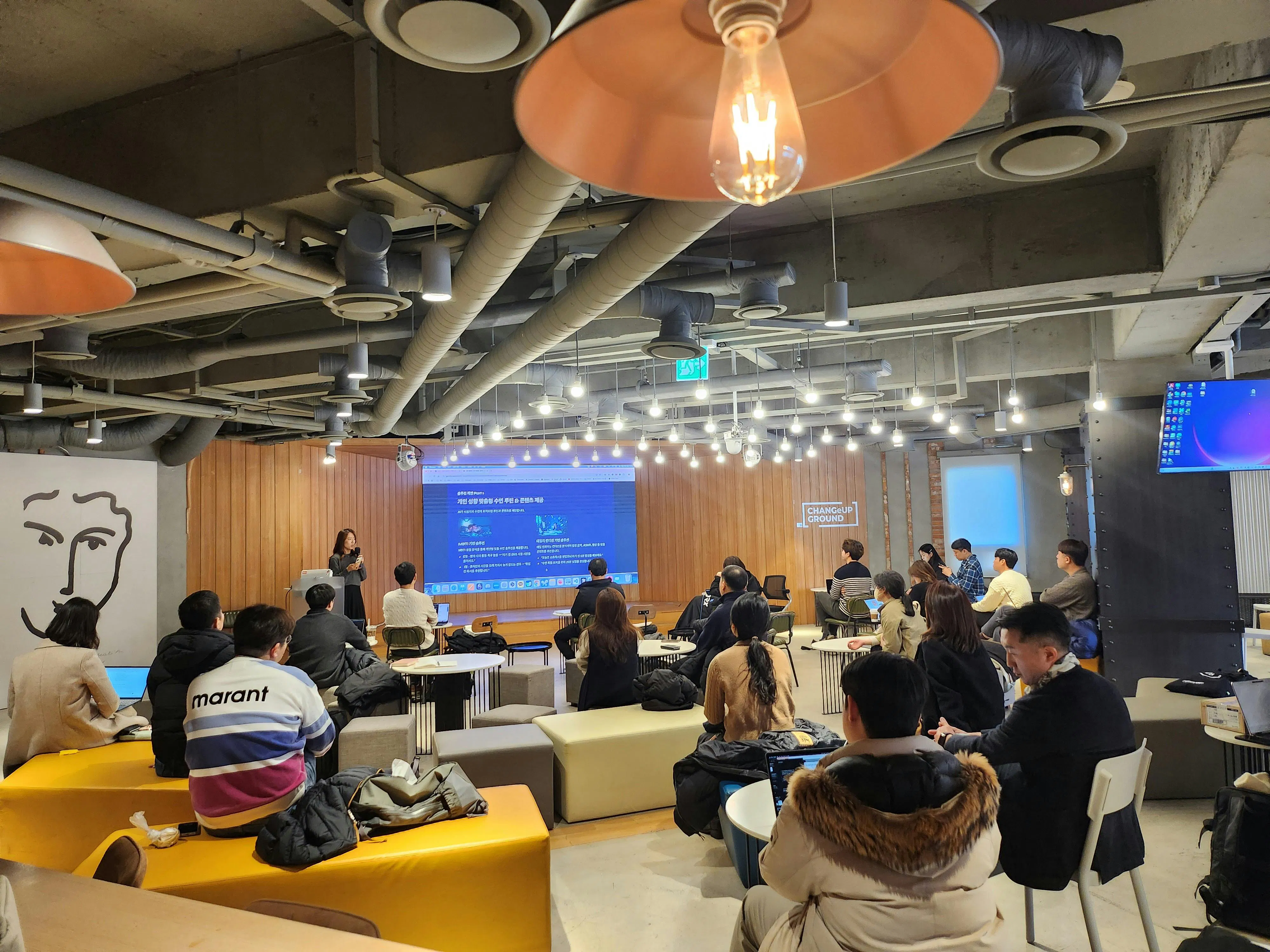 한 무리의 사람들이 회의실에 앉아 있다