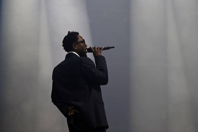 Man in suit performing with a microphone on stage