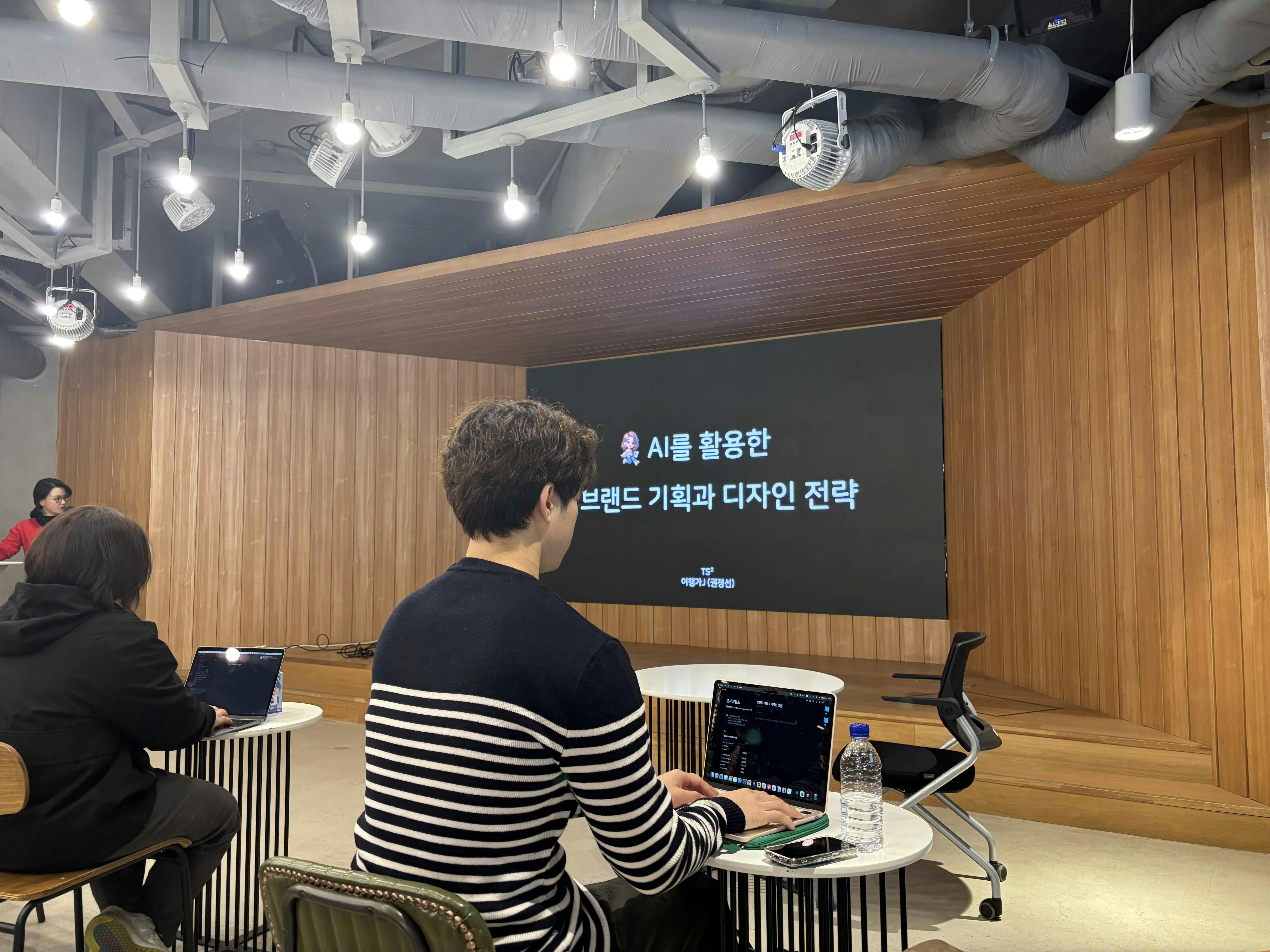 한 무리의 사람들이 스크린 앞 테이블에 앉�아 있다