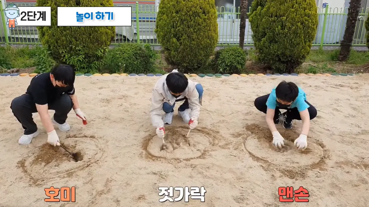 한 무리의 사람들이 모래에 구멍을 파고 있다