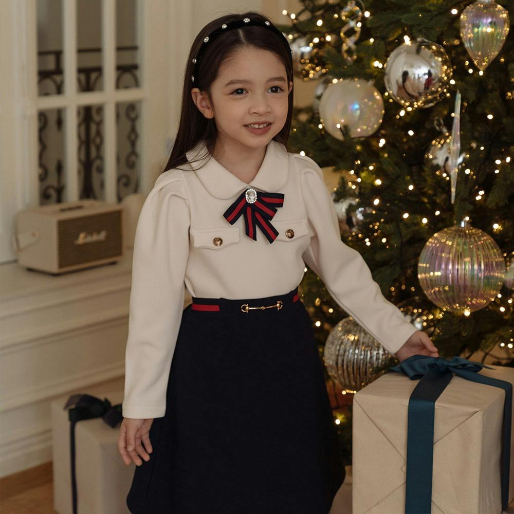 크리스마스 트리 앞에 서있는 어린 소녀