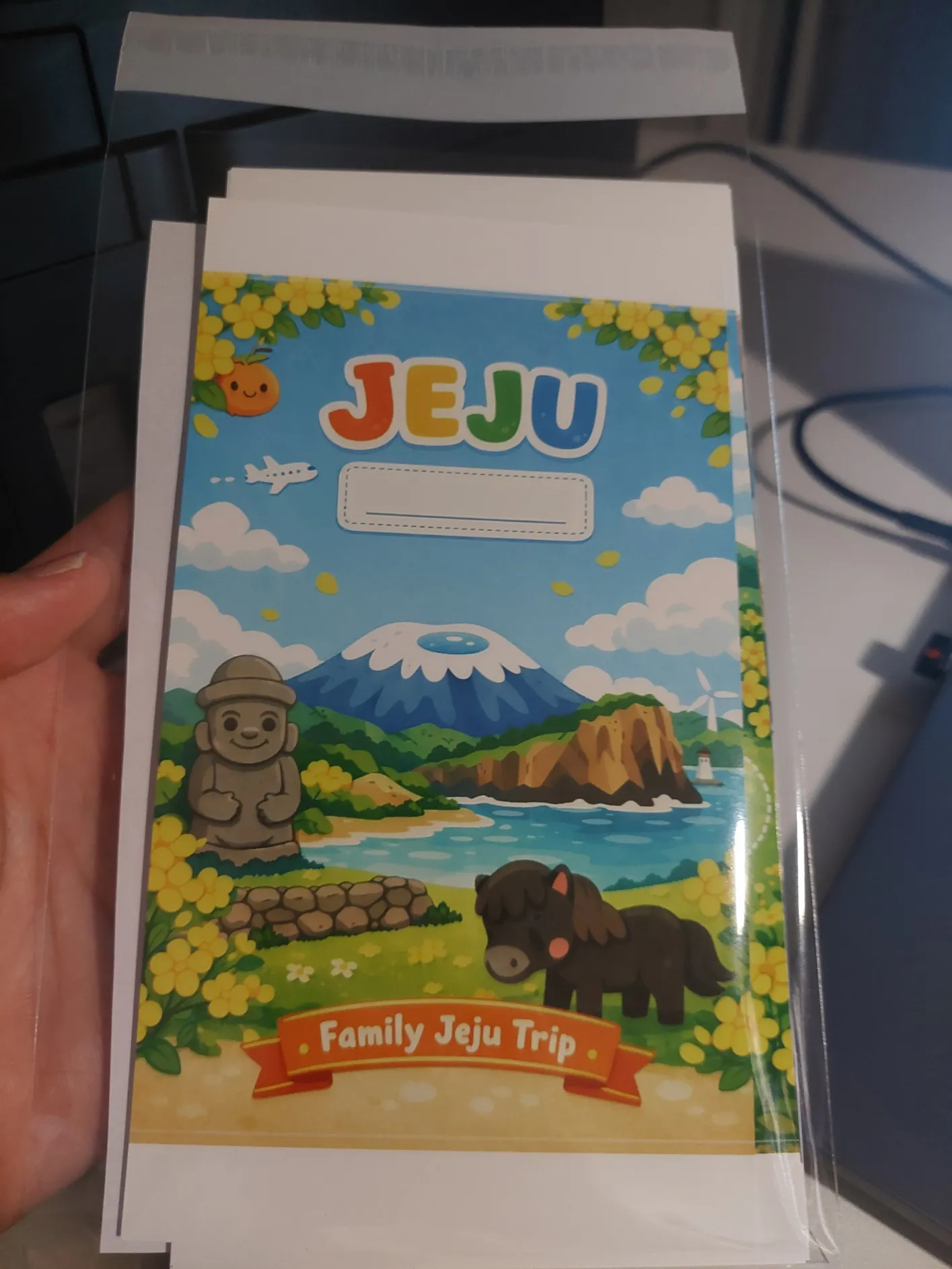 제주 가족여행 책자를 들고 있는 사람