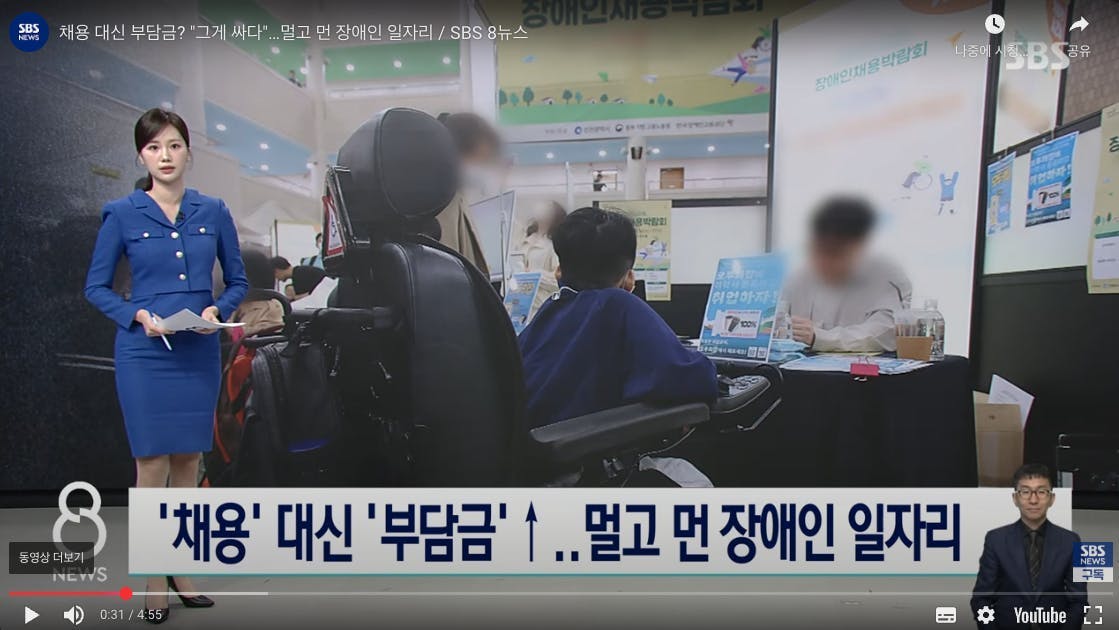 여자가 텔레비전 화면 앞 의자에 앉아 있습니다.