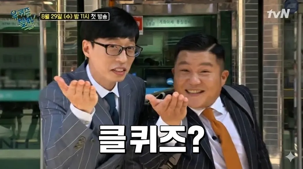양복을 입은 두 남자가 나란히 서 있다