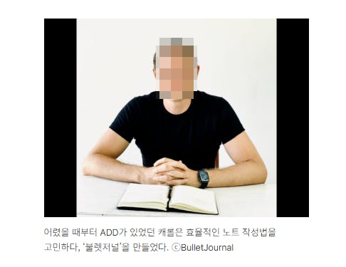그 앞에 책이있는 테이블에 앉아있는 남자