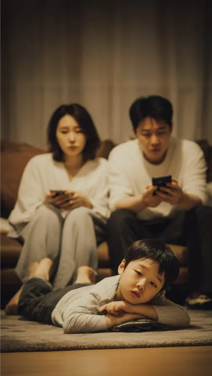 어린 소년과 함께 소파에 앉아 전화를보고있는 한 가족