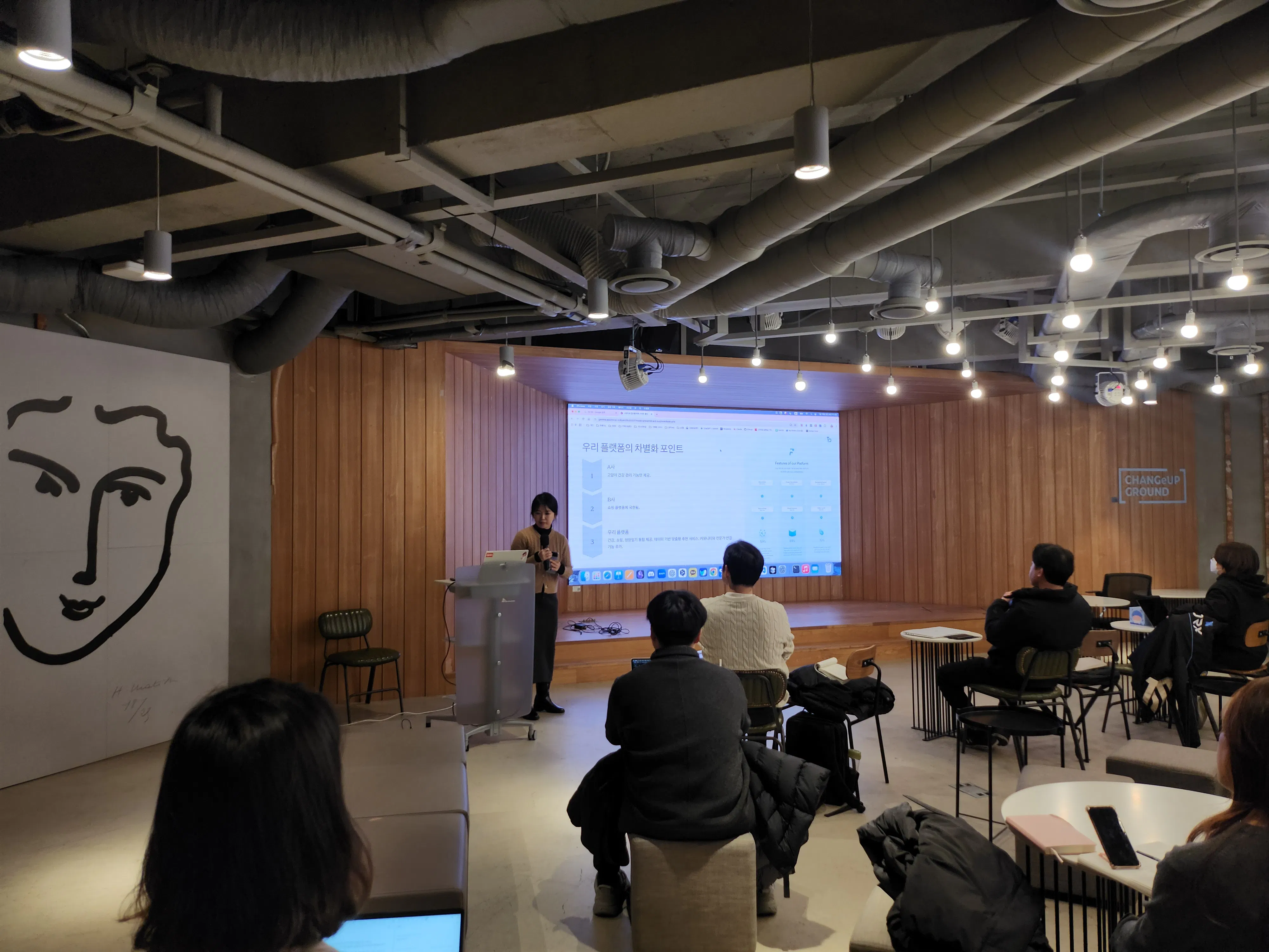 한 무리의 사람들이 프로젝터를 들고 방에 앉아 있다