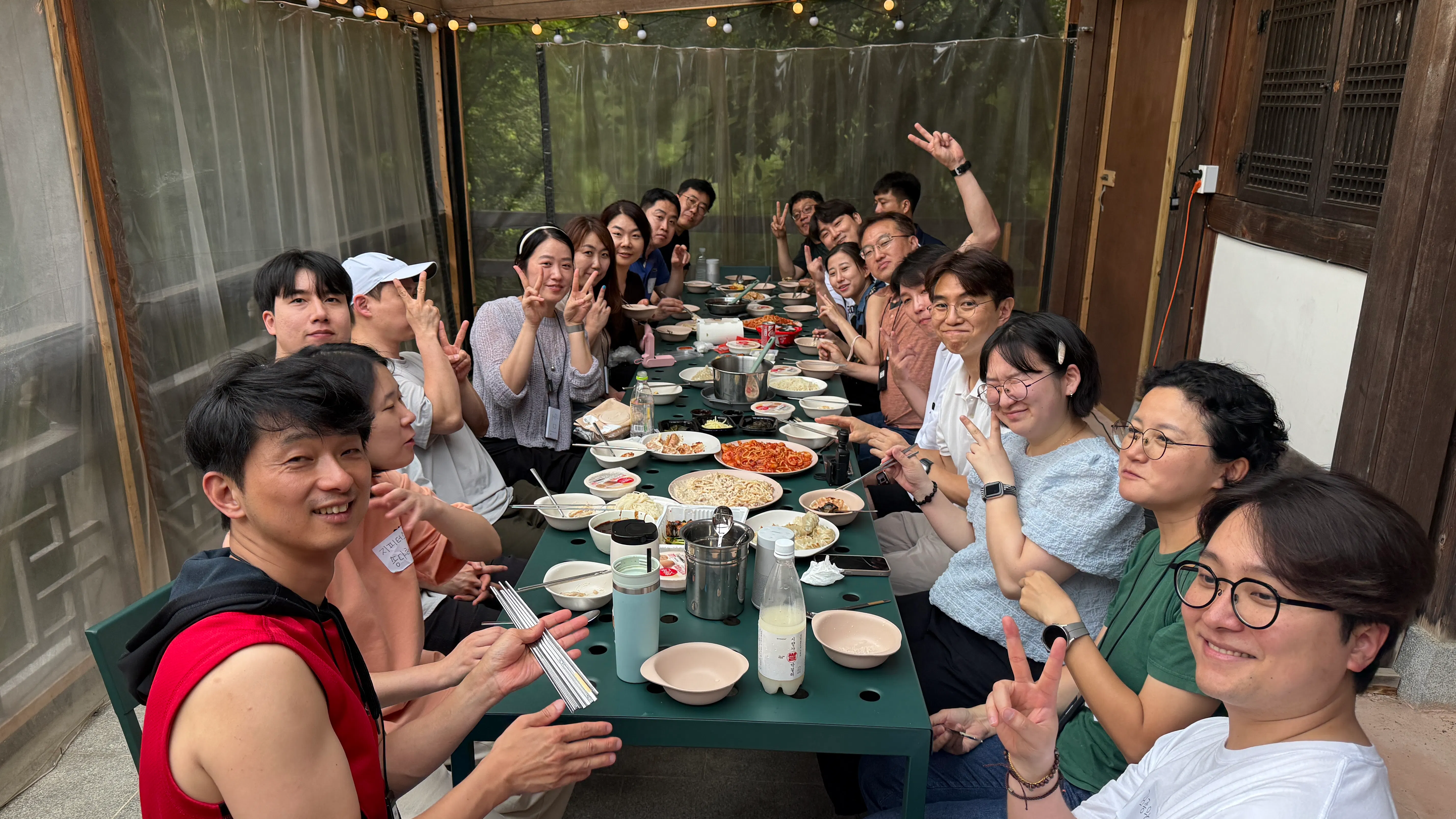 한 무리의 사람들이 테이블 주위에 앉아 음식을 먹고 있다