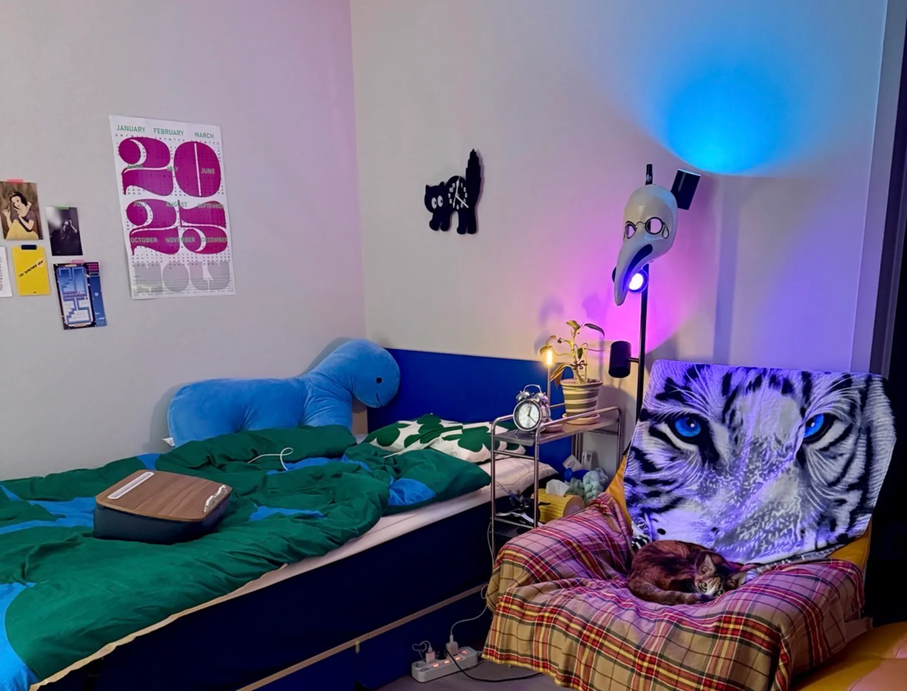 파란 가구와 초록 침구, 보라색과 파란색 조명이 있는 방 레퍼런스