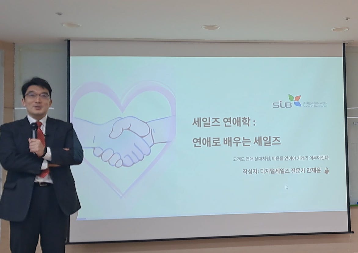양복을 입은 남자가 프로젝터 앞에 서 있다