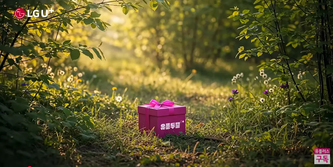 잔디밭 한가운데에 앉아 분홍색 선물 상자