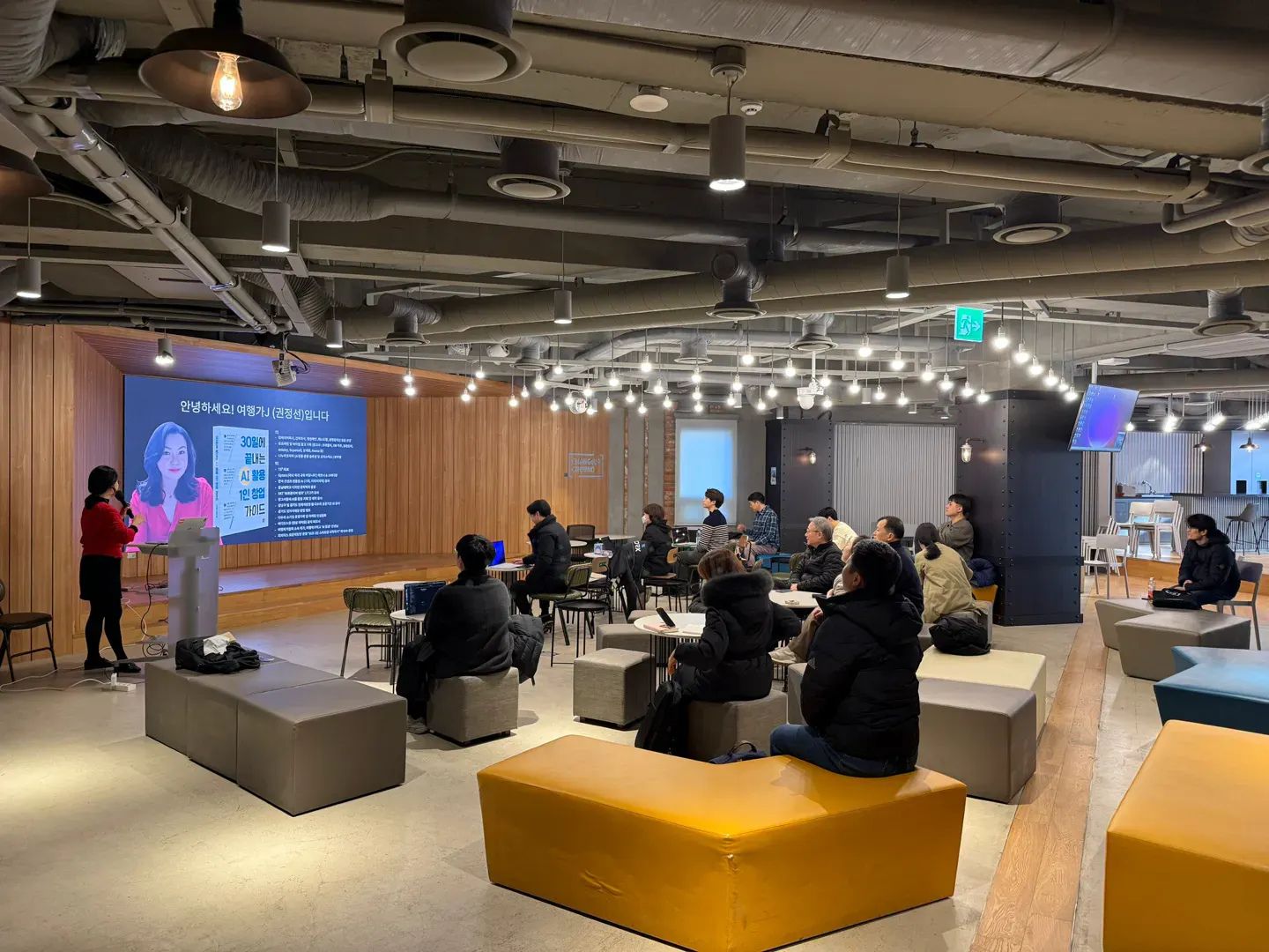 한 무리의 사람들이 회의실에 앉아 있다