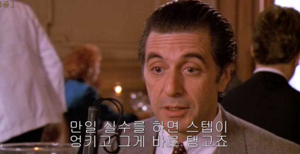 양복을 입은 남자가 테이블에 앉아 있다