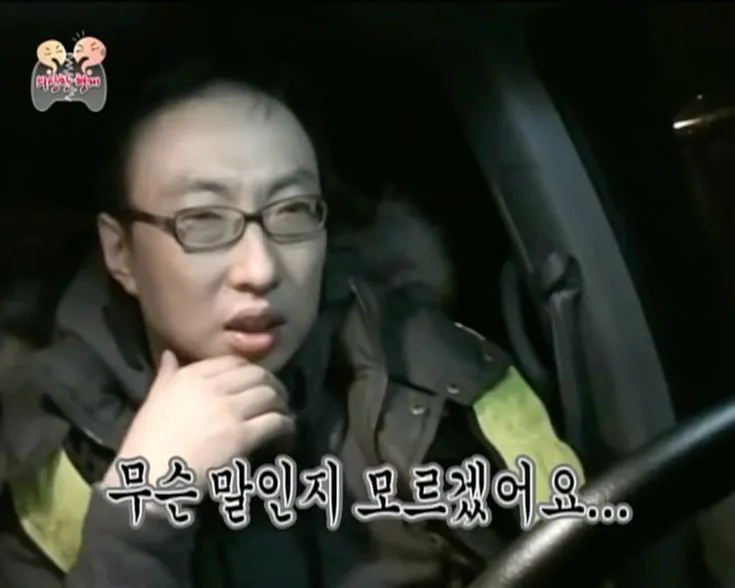 안경을 쓴 남자가 밤에 차를 운전하고 있다