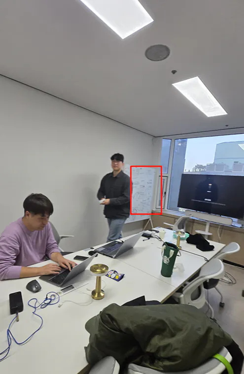 그 앞에 노트북이있는 테이블에 앉아있는 사람들 그룹