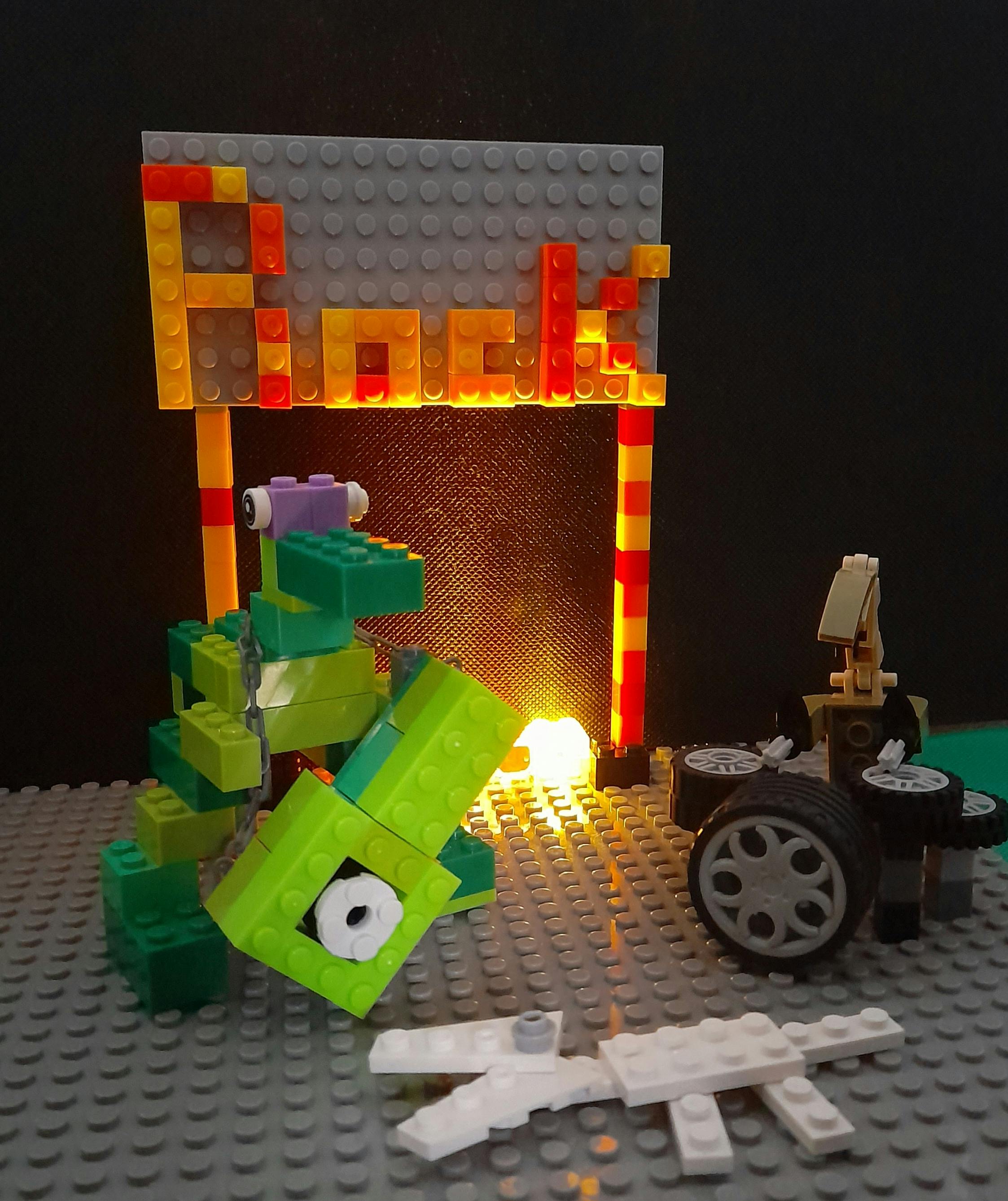 A scene constructed entirely from Lego, with the word 'Rock' spelt out on a banner at the top. Beneath it are a guitarist with a blocky guitar and a drummer playing drums made out of tyres. It's all illuminated by a glowing brick at the back.