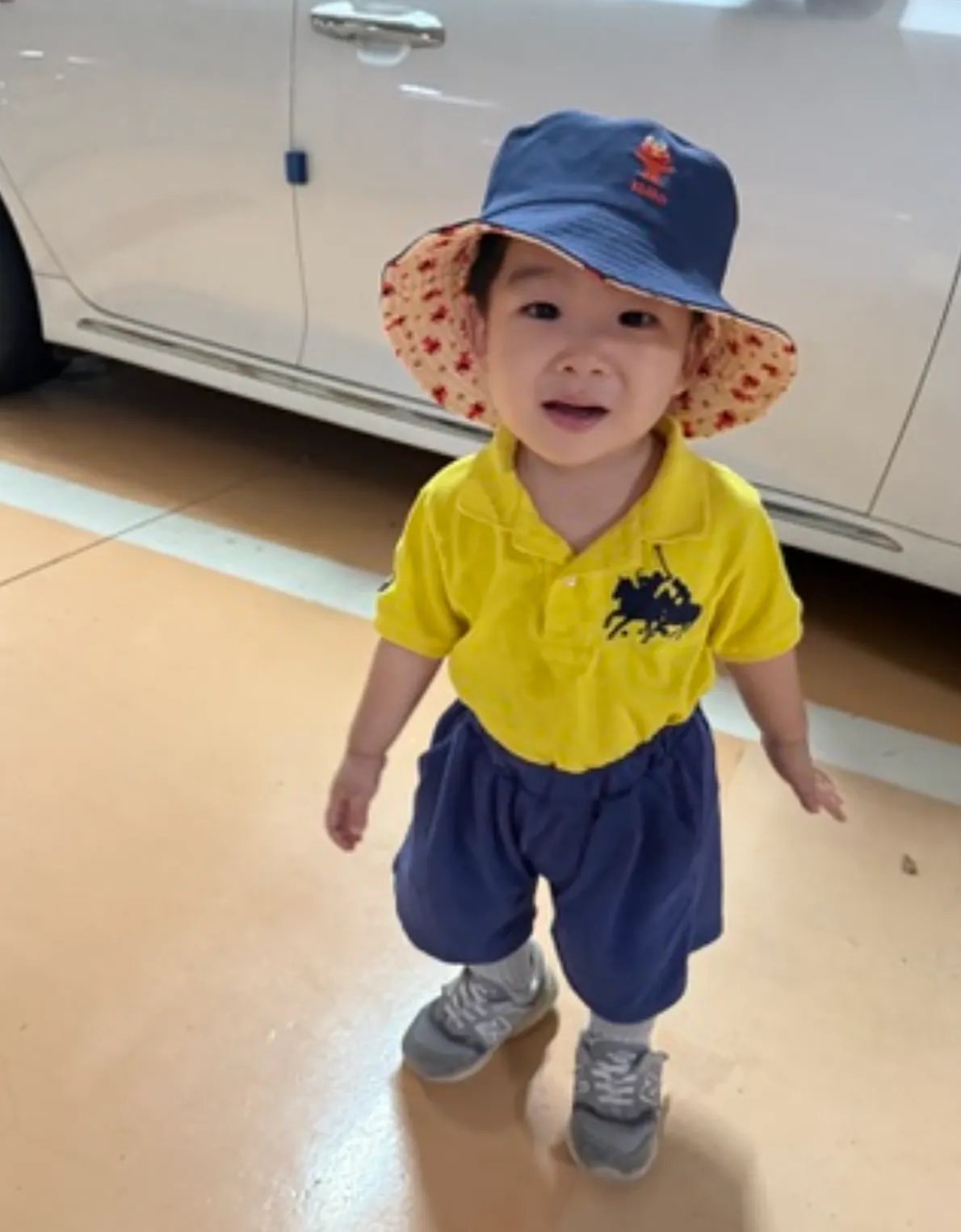 차고에서 모자와 반바지를 입은 아기