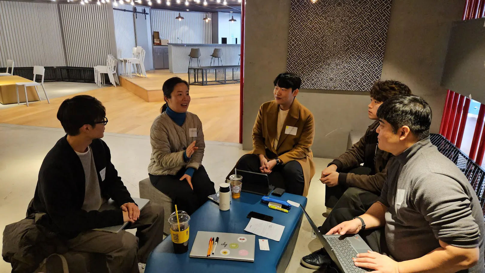 한 무리의 사람들이 방의 테이블 주위에 앉아 있다