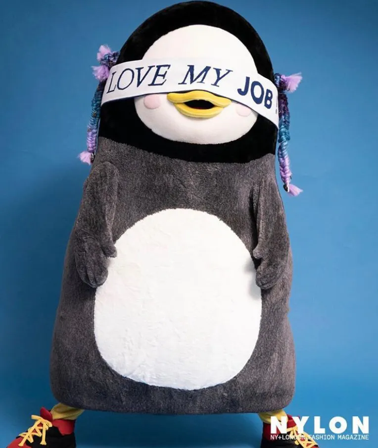 내 일을 사랑해요라고 적힌 피켓을 달고 있는 박제 펭귄