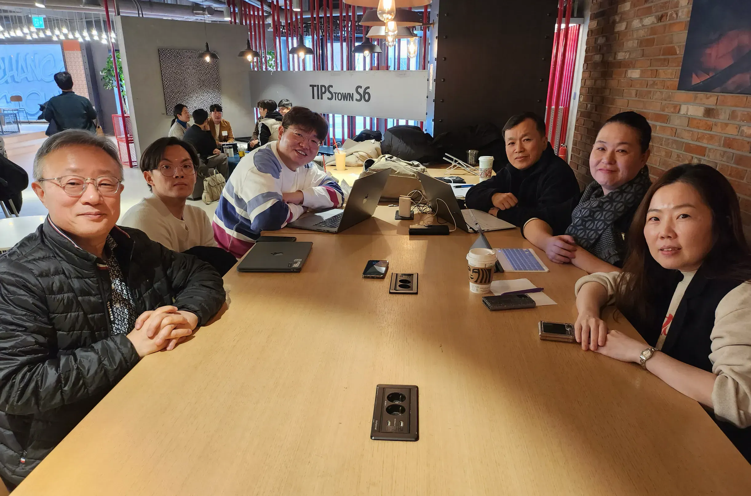 한 무리의 사람들이 테이블 주위에 앉아 있다