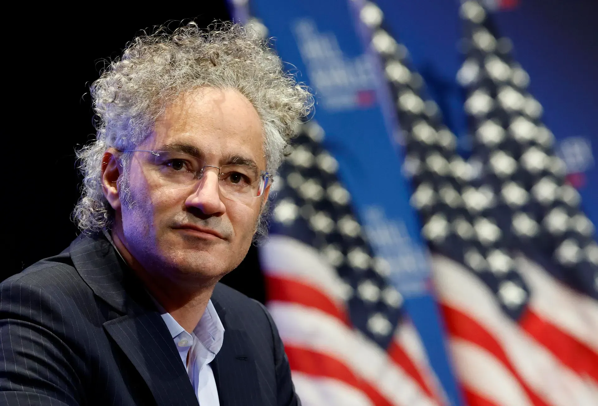 미국 국기 앞에 곱슬머리를 한 남자