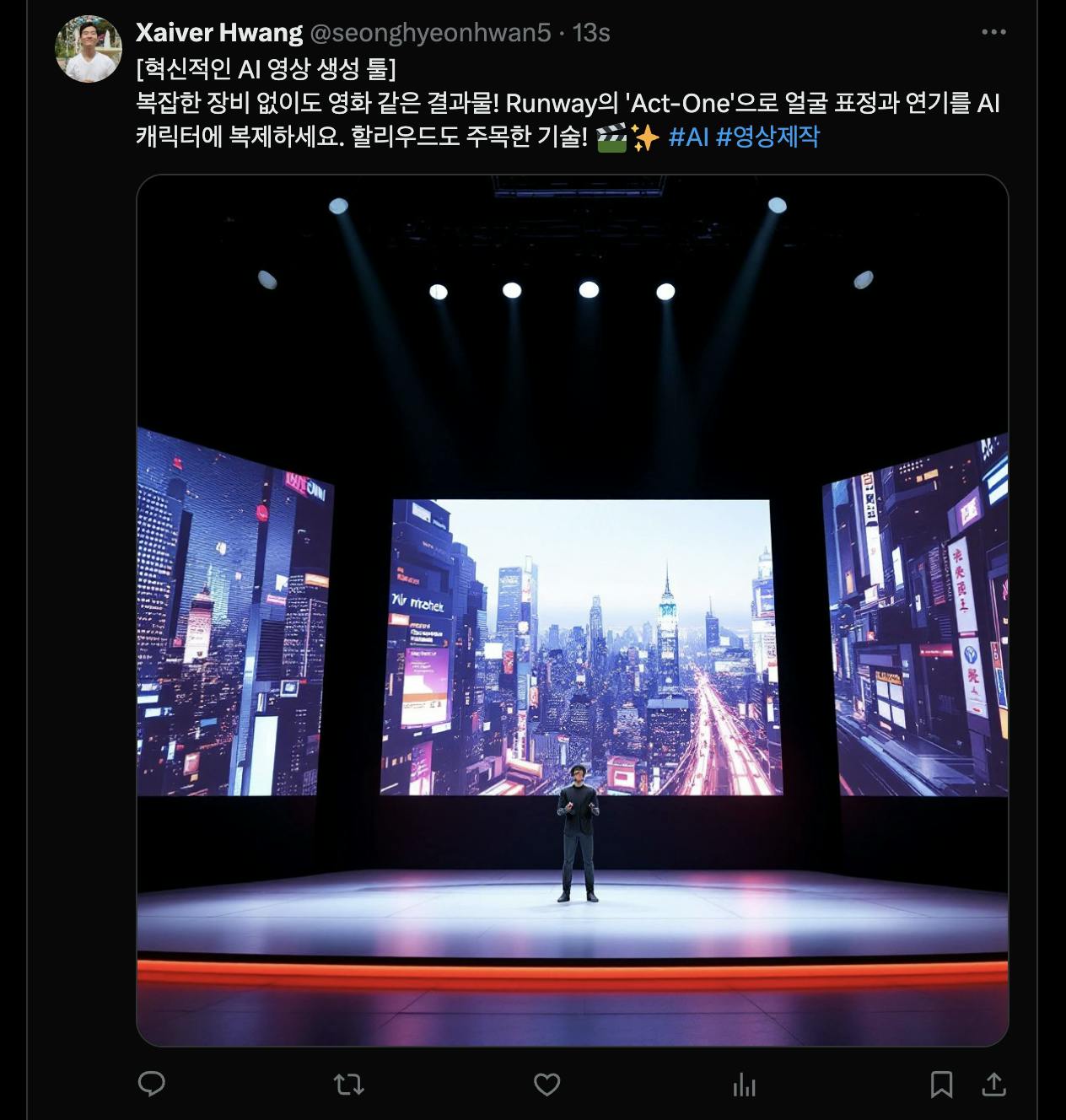 한 남자가 대형 스크린 앞 무대에 서 있다