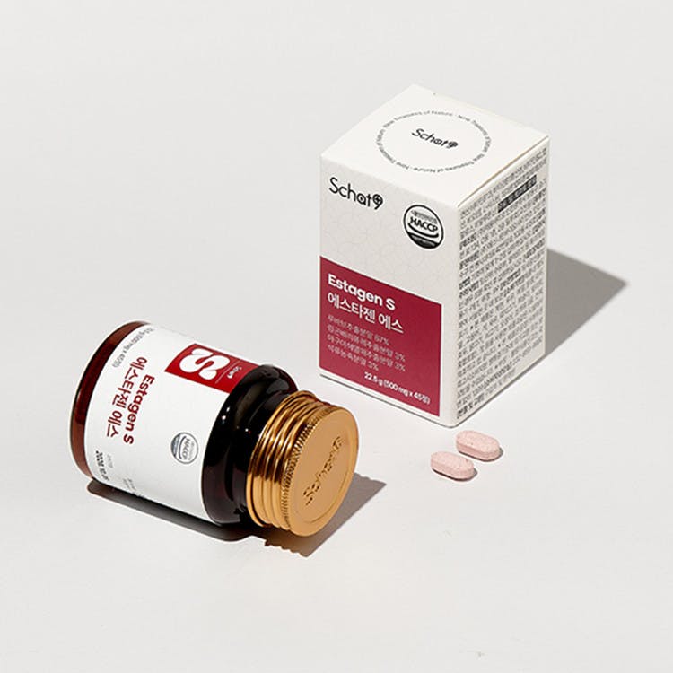 상자 옆에 앉아있는 비타민 C 한 병