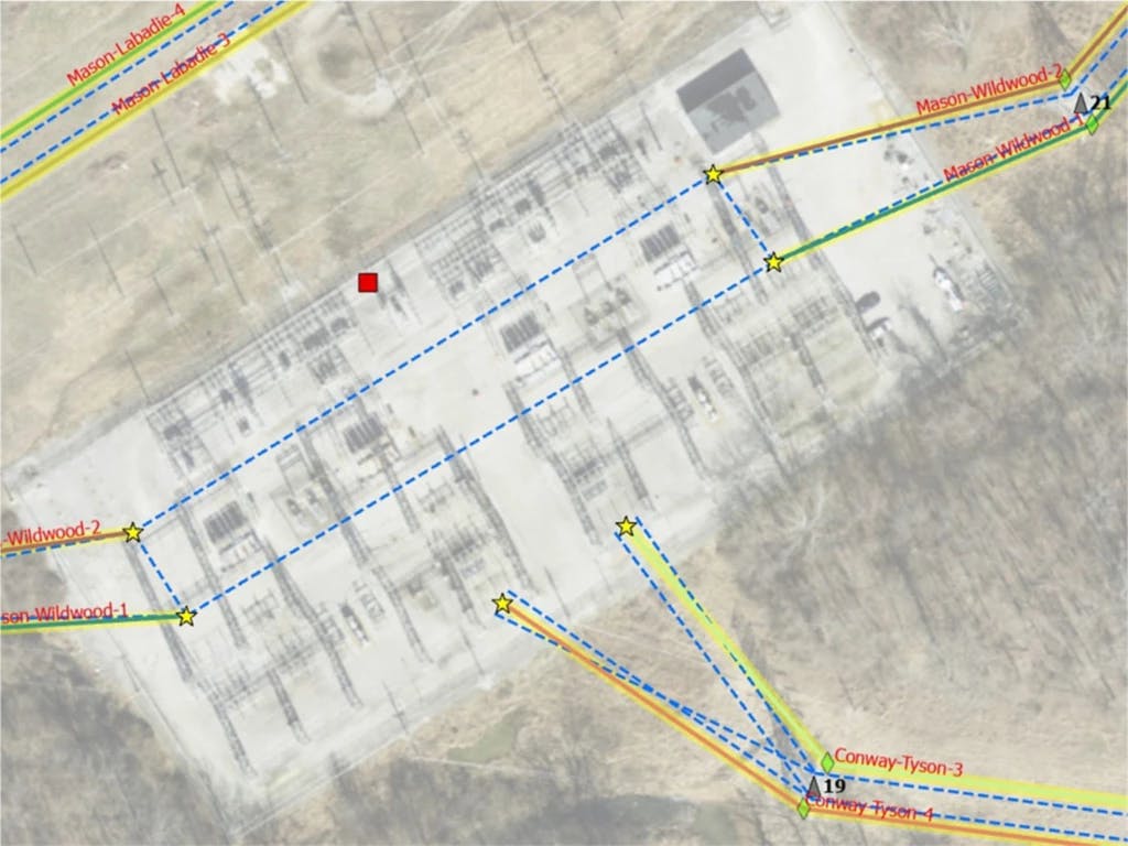 Aerial view of a large industrial site with yellow and blue lines indicating power lines