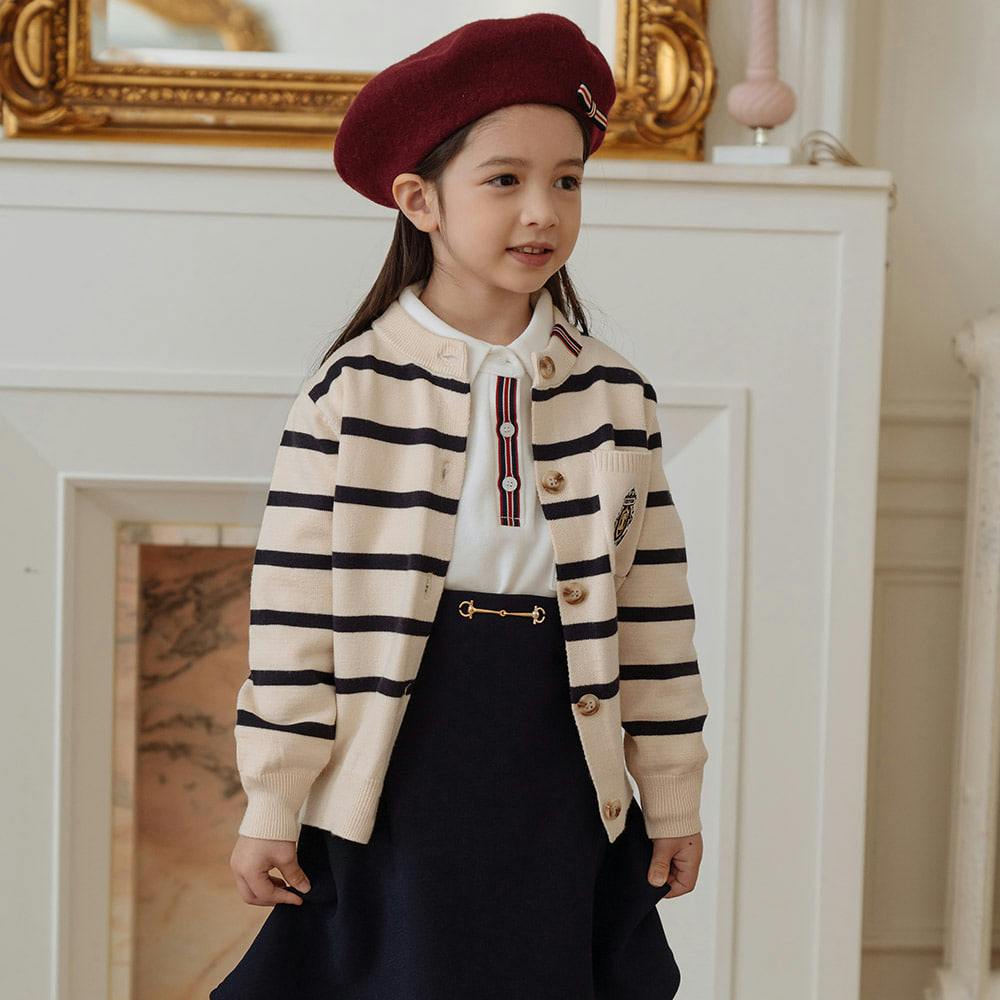 줄무늬 가디건과 치마를 입은 어린 소녀